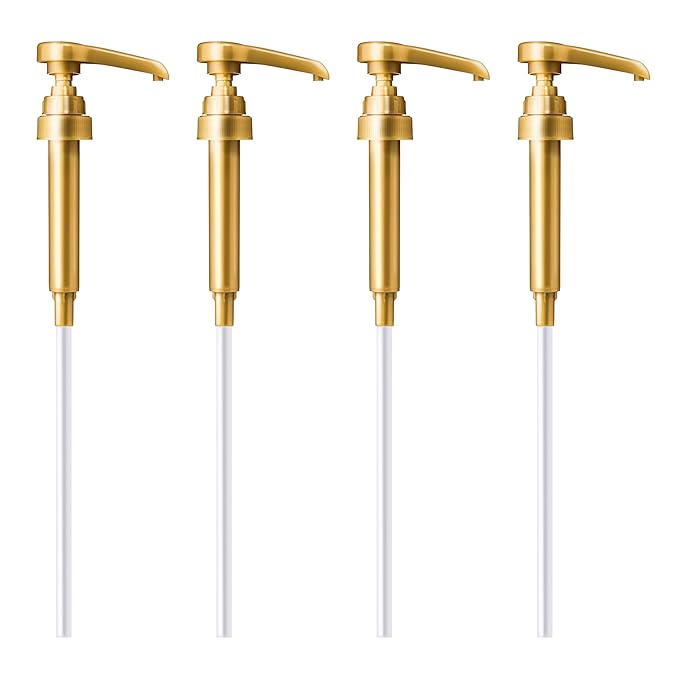 Four gold metal soap dispenser pumps with long white tubes on white background