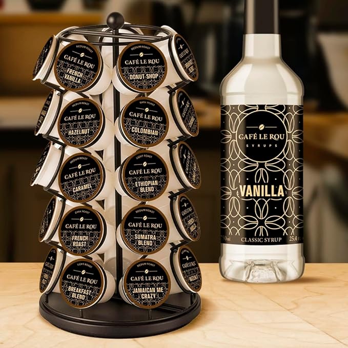 Rotating stand with Café Le Rou coffee pods in various flavors and a bottle of Café Le Rou vanilla syrup on a wooden table